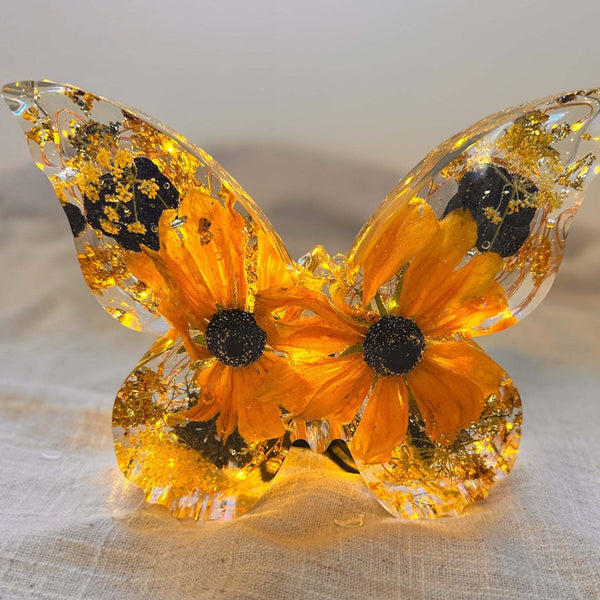 Light up resin butterfly decor featuring a clear resin butterfly with orange blooms, black centres and gold leaf accents