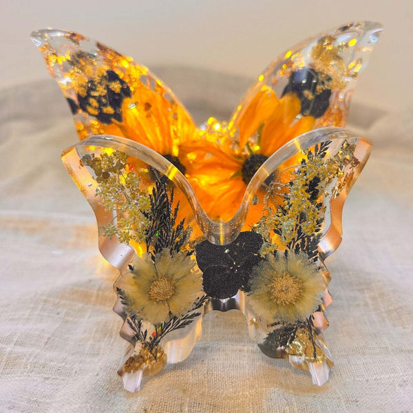 Light up resin butterfly decor set in clear resin, featuring glowing orange LEDs, pressed yellow flowers, black blooms and gold leaf
