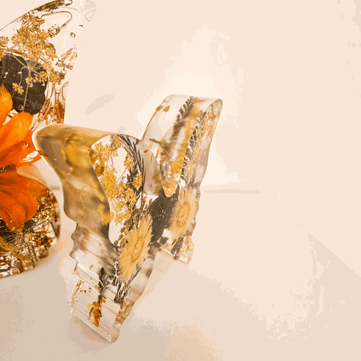 light up resin butterfly decor set in clear resin with pressed botanicals, gold leaf and warm orange floral accents, two-piece design