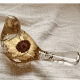 Handmade resin bird decor featuring a preserved Sunflower with a dark center, gold leaf, and clear amber-tinted resin.