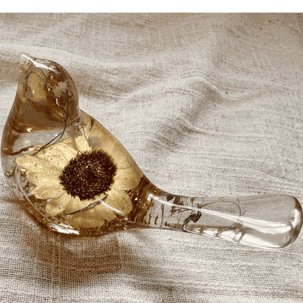 Handmade resin bird decor featuring a preserved Sunflower with a dark center, gold leaf, and clear amber-tinted resin.