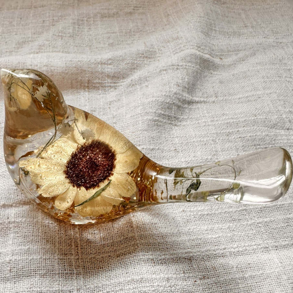 Resin bird decor with a clear finish, pressed yellow Sunflower, delicate green botanicals and shimmering gold leaf.