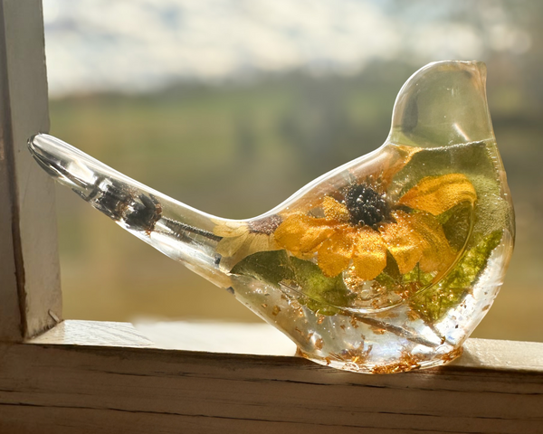 Sunflower Songbird resin bird decor with clear body, golden yellow sunflower, green foliage and gold flecks.
