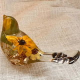 Resin bird decor, Sunflower Songbird with golden amber coloring, embedded yellow blooms, and lavender sprigs in its clear tail.