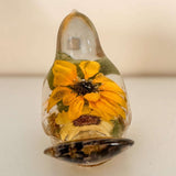 Sunflower Songbird resin bird decor with vivid yellow-orange blooms, a dark seeded centre, and gold-toned base.