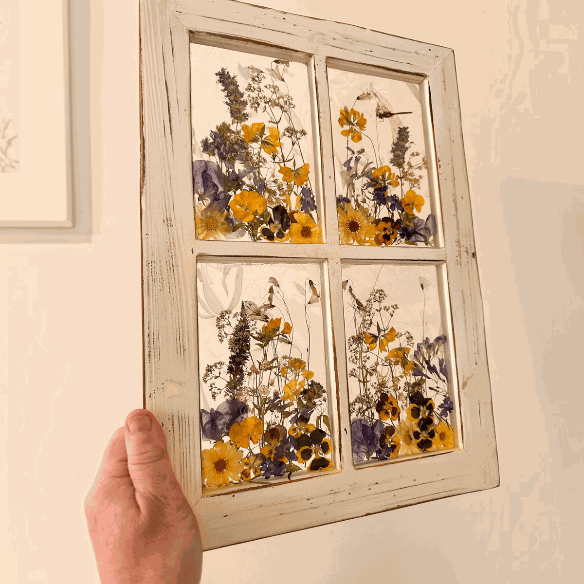 Pressed Flower Window Frame with real yellow and purple botanicals in four clear resin panes, set in distressed white wood.