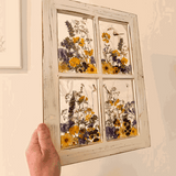 Pressed Flower Window Frame with real yellow and purple botanicals in four clear resin panes, set in distressed white wood.