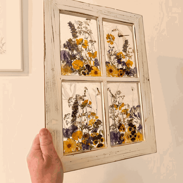 Pressed Flower Window Frame with real yellow and purple botanicals in four clear resin panes, set in distressed white wood.