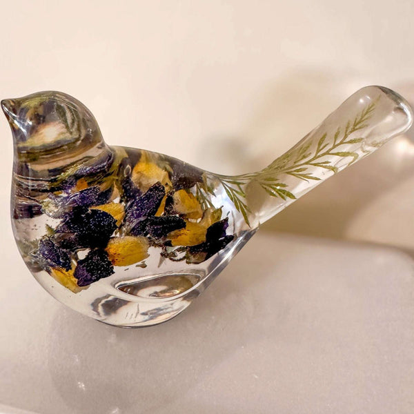 Blue Lupine resin bird decor in clear resin, with deep purple and golden yellow flowers and green botanicals in its tail.