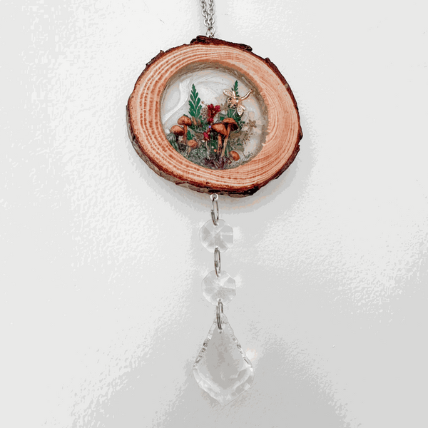 Suncatcher made from a natural wood slice with bark edge, miniature forest botanicals in resin and clear crystal drops