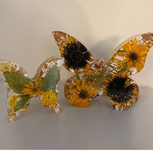 Light up resin butterfly decor set with two clear resin butterflies, pressed yellow flowers, green leaves and gold accents