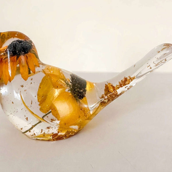 Resin bird with a clear body, Golden Meadow yellow flowers, dark centers and shimmering gold leaf accents.