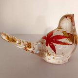 Maple Leaf Songbird in clear resin, featuring a red maple leaf and scattered gold accents with a glossy finish.