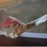 Maple Leaf Songbird in clear resin with a red maple leaf, gold flecks, and a smooth sculpted bird shape.