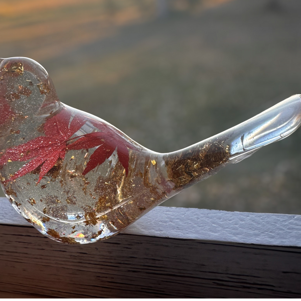 Maple Leaf Songbird in clear resin with a red maple leaf, gold flecks, and a smooth sculpted bird shape.