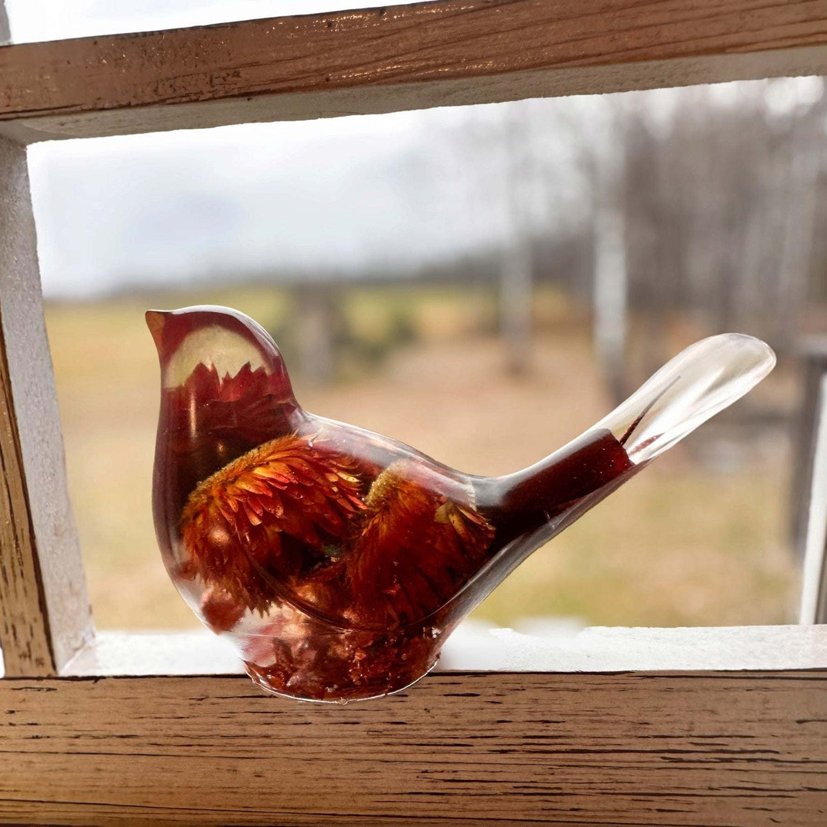 Resin Bird Pair of a clear resin bird with deep red and orange strawflowers, a raised tail, and copper-toned base.
