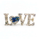 forget me not resin love sign in clear resin with blue pressed flowers, delicate greenery and silver leaf LOVE lettering
