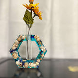 A hexagon shaped propergation bud vase created with Epoxy Resin. The first layer is filled with real seashells, the background layer is a bright teal blue. Comes with a test tube that will hold your favourite flower or plant you wish to start and root
