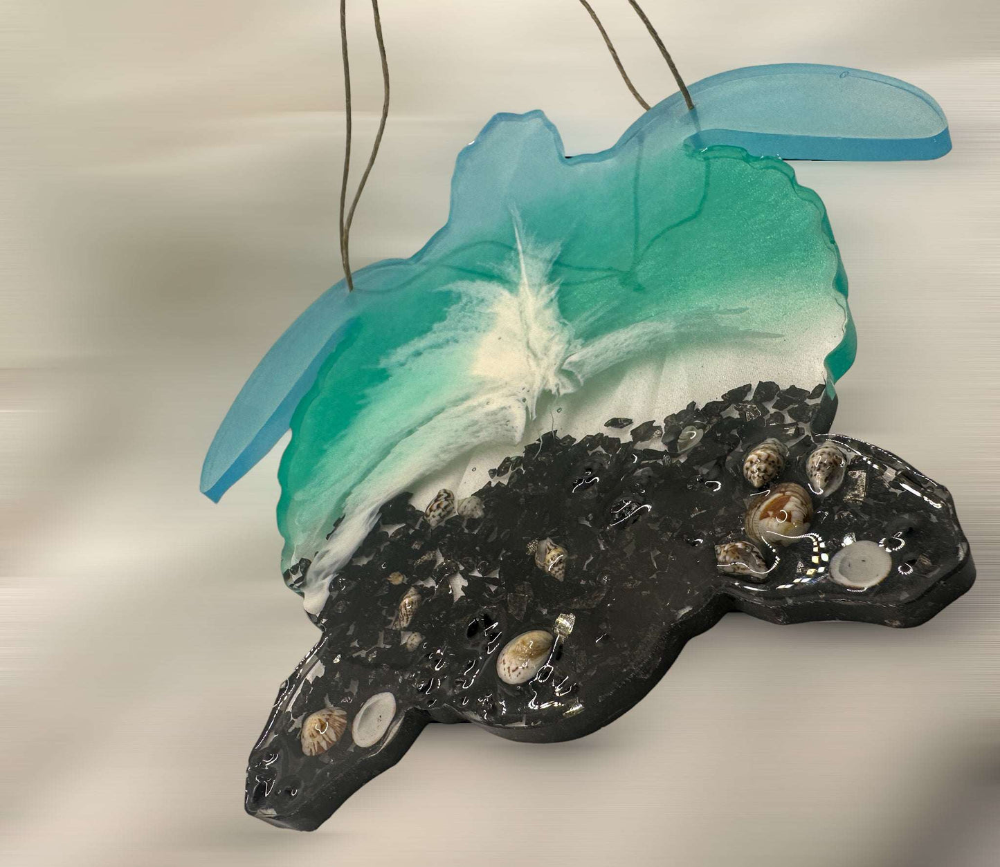 A turtle shaped Wall Hanger with a black beach, real seashells and turquoise blues for the ocean. Gift idea for turtle lovers