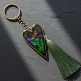 Aurora dragonfly keychain with a silver heart frame, green ferns in purple-green resin, and a long green tassel.