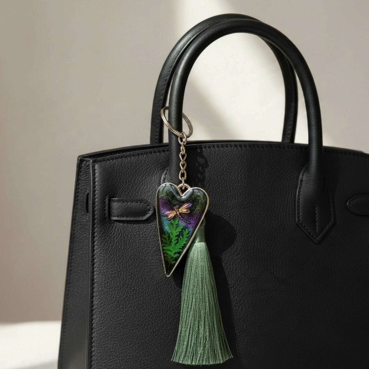 Aurora dragonfly keychain with a silver heart-shaped resin charm, green ferns, purple-green shimmer and green tassel.