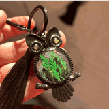 Bag Charm featuring a dark gunmetal owl frame, green pressed ferns in shimmering resin, jeweled eyes and black tassel