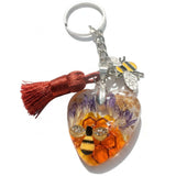Honeybee Heart Bag Charm with rhinestone bee, pressed purple flowers, golden honeycomb, enamel bee charm, and copper tassel on silver keychain ring