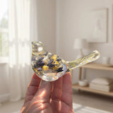 Blue Lupine resin bird decor in clear resin, with embedded violet-blue and golden botanicals and a transparent tapered tail.