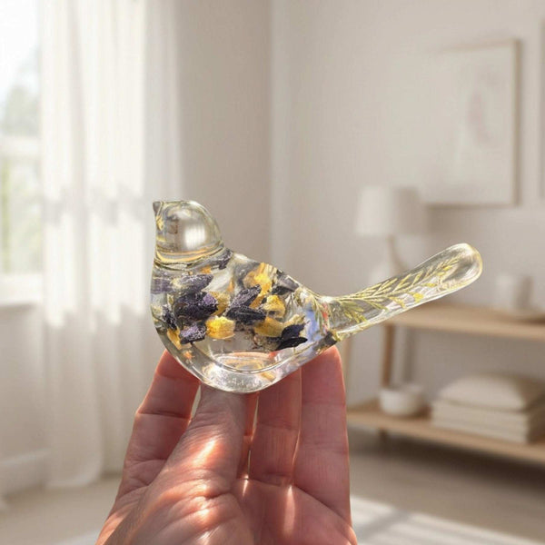 Blue Lupine resin bird decor in clear resin, with embedded violet-blue and golden botanicals and a transparent tapered tail.