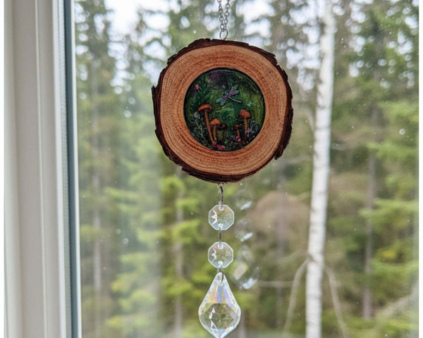 Boreal forest suncatcher with a natural bark-edged wood slice, colorful mushroom scene in resin, and dangling clear crystals