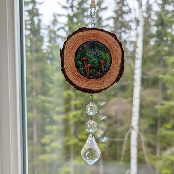 Boreal forest suncatcher with a natural bark-edged wood slice, colorful mushroom scene in resin, and dangling clear crystals