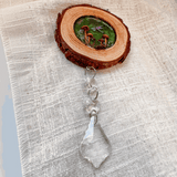 boreal forest suncatcher with a natural bark-edged wood slice, tiny mushrooms and moss, and a clear hanging crystal