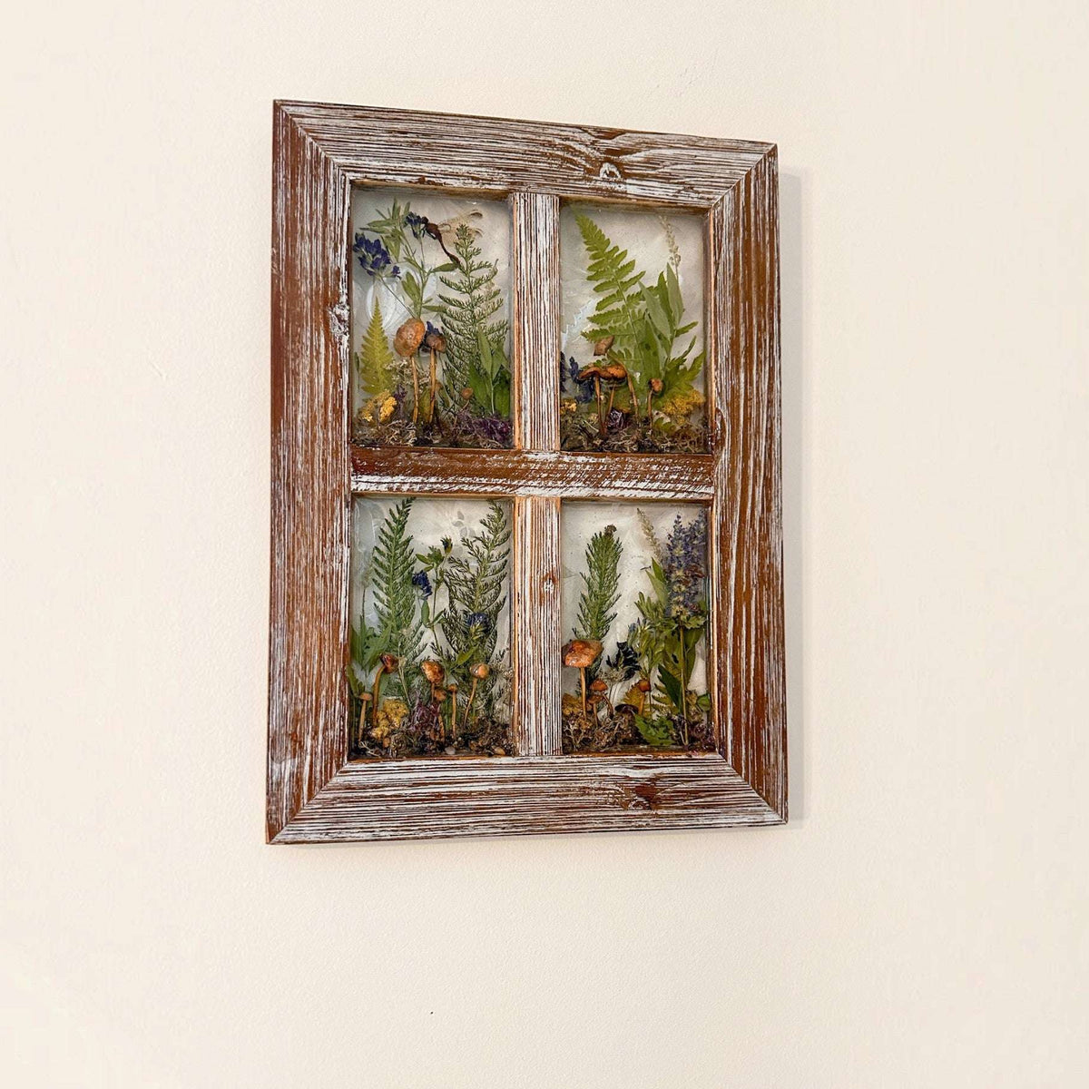 boreal forest window art featuring four botanical resin panes with mushrooms, green ferns and wildflowers in a weathered wood frame
