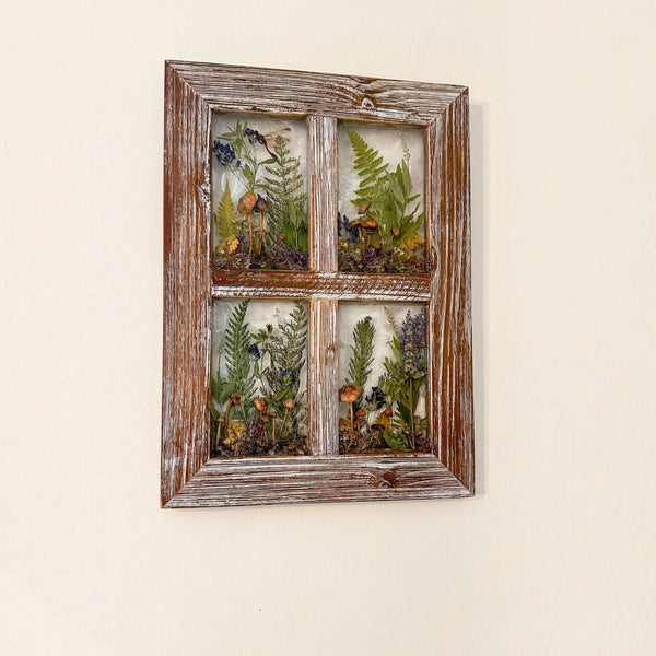 boreal forest window art featuring four botanical resin panes with mushrooms, green ferns and wildflowers in a weathered wood frame