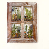 boreal forest window art in a distressed whitewashed wood frame, with four resin panes of mushrooms, ferns and moss