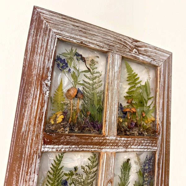 boreal forest window art in a distressed brown wood frame, with four resin panes of mushrooms, ferns and moss