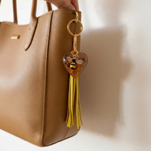 bumble bee resin keychain with an amber heart, pressed flowers, bee charm and long golden yellow tassel