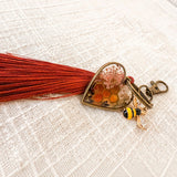 bumble bee resin keychain with an antique bronze heart, amber honeycomb, pressed flowers, bee charm and rust tassel