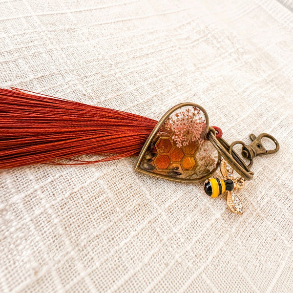 bumble bee resin keychain with an antique bronze heart, amber honeycomb, pressed flowers, bee charm and rust tassel