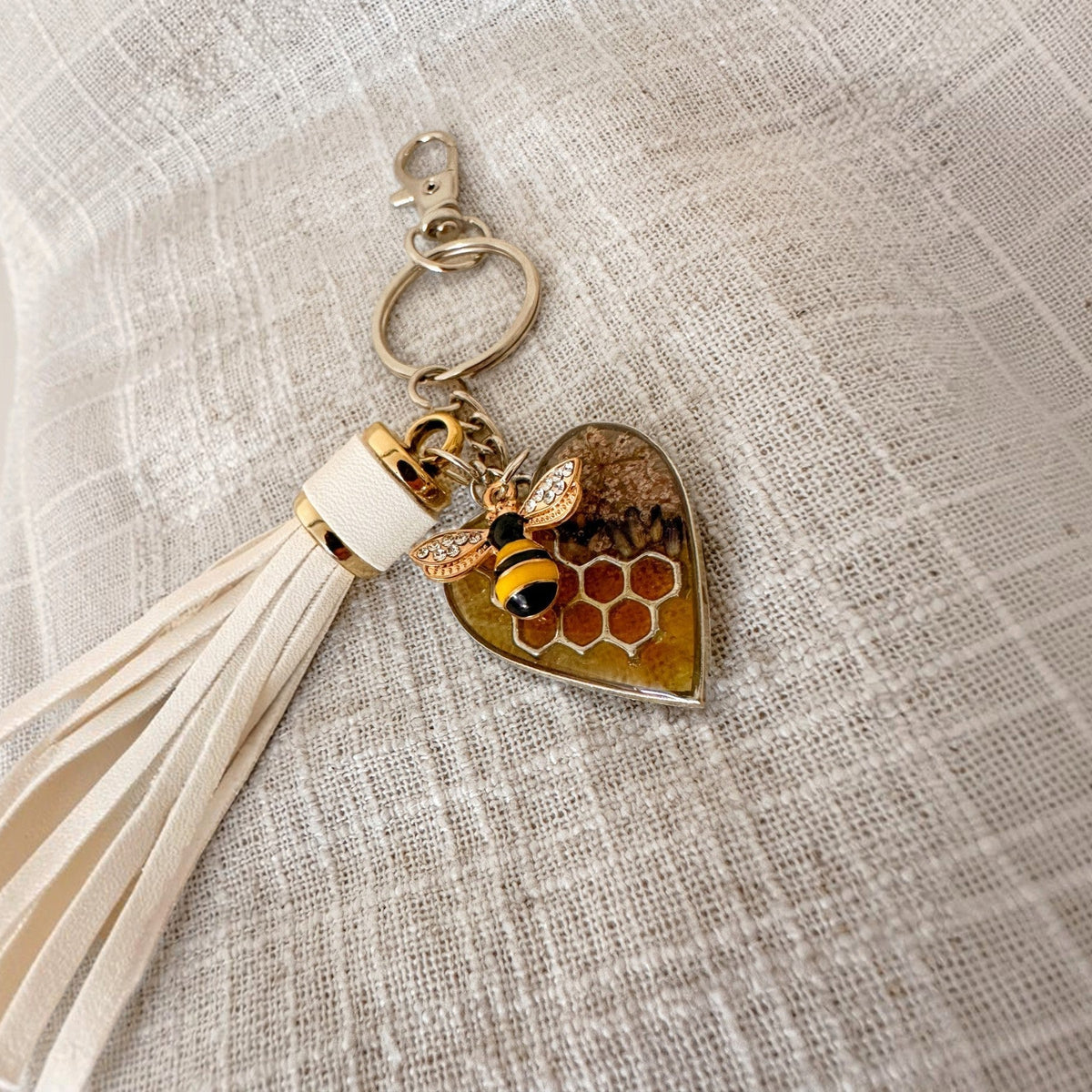bumble bee resin keychain with a honey-gold heart, visible honeycomb, crystal-winged bee charm and cream tassel