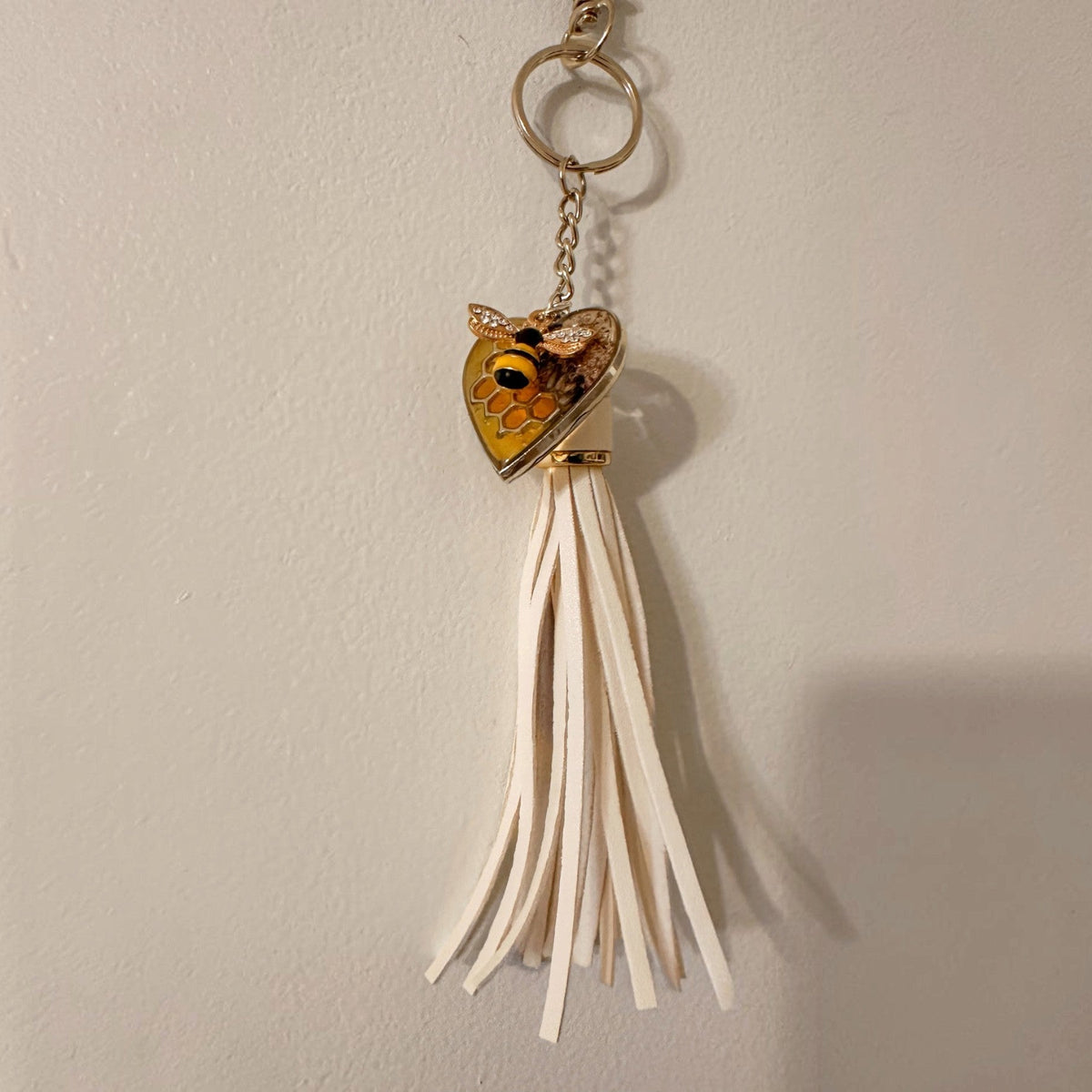 bumble bee resin keychain with a honey-gold heart, bee motif and long ivory tassel on a gold-tone ring