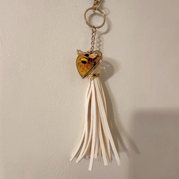 bumble bee resin keychain with a honey-gold heart, bee motif and long ivory tassel on a gold-tone ring