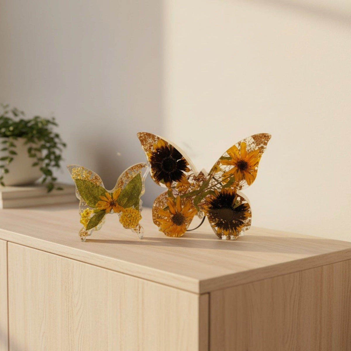 Light up resin butterfly decor set with two clear resin butterflies, amber and yellow dried flowers, green leaves and gold accents