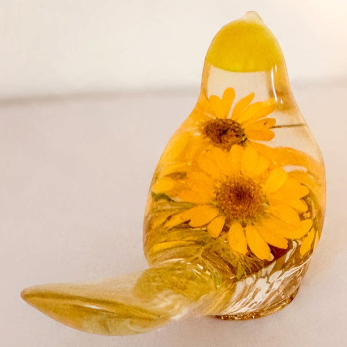 yellow canary resin bird with real yellow daisies, green foliage, and gold leaf base, handmade in Alberta