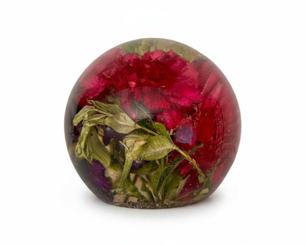 Floral resin sphere with dark pink and purple carnations and green botanicals glowing on LED base