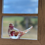 Side view of a cherry blossom resin bird with coral wheat in the tail