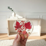 Red maple leaf resin tray in a clear heart shape, with crimson and blush foliage and scattered gold leaf.