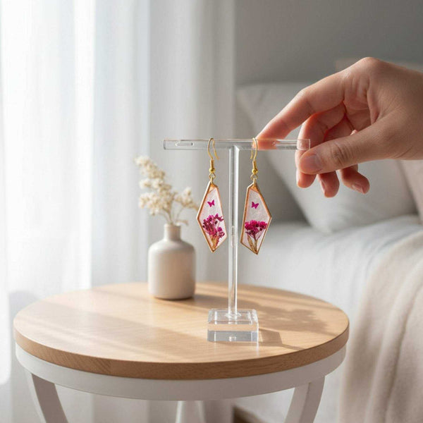 Handcrafted geometric gold-framed Pink Butterfly resin earrings with pink flowers and a butterfly.