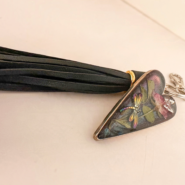 dragonfly resin keychain with a bronze-edged heart, colourful dragonfly, pressed rose and leaves, and black tassel