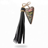 dragonfly resin keychain with a pressed pink rose and colorful dragonfly in a smoky heart, finished with a black leather tassel